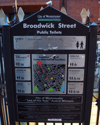 An official sign next to the public toilets displaying the opening hours and other information